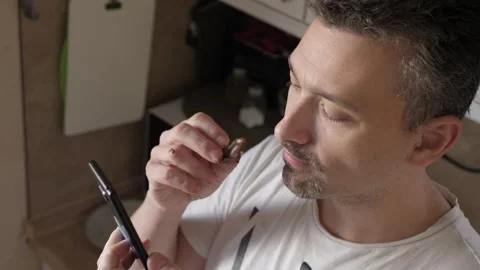 A man enjoys a cookie while scrolling on his phone Stock Footage 318321141