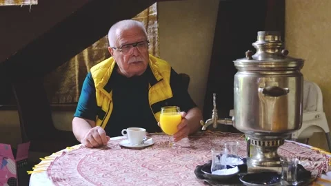 Man enjoys drinking fresh orange juice sitting at table Stock Footage 135443229