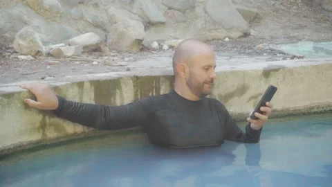 A man enjoys a hot spring in the mountains. Vidéo 133569745