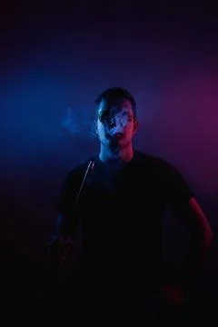 Man enjoys a moment of tranquility while smoking in neon-lit hookah bar Stock Photos