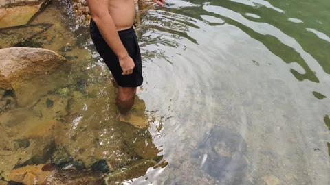 Man enjoys refreshing cold water swim. Tropical wilderness promotes robust mens Stock Footage 322218122