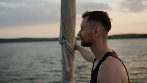 A man enjoys the setting sun while walking on a boat Stock Footage 201192544