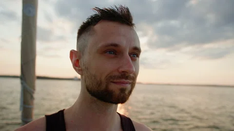 A man enjoys the setting sun while walking on a yacht Stock Footage 235992880