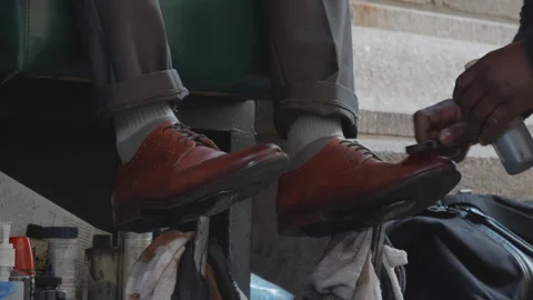 Man enjoys shoe polishing service on busy city street corner Stock-Footage 312684553