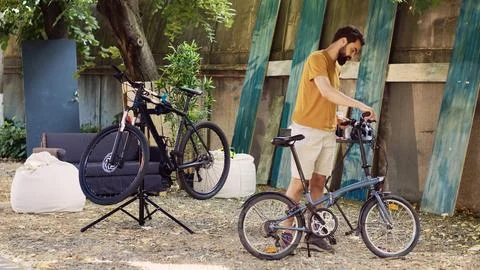 Man ensuring bicycle function in yard 库存照片