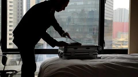 Man enter hotel room, put suitcase on bed and laptop on it, stoop over 스톡 동영상 102890784