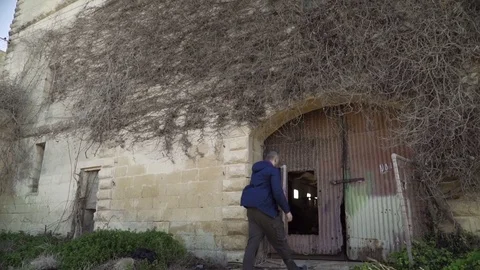 Man entering abandoned warehouse - longshot Stock Footage 73674964