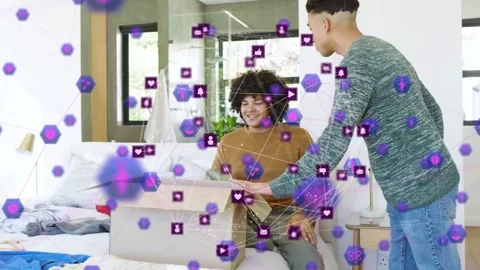 Man entering carrying box moving in pal sorting clothes as purple tech overlay Stock Footage 333975337