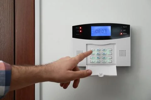 Man entering code on home security system near door, closeup Stock Photos