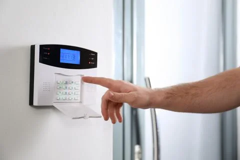 Man entering code on home security system near door, closeup Stock Photos