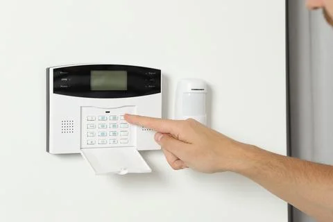 Man entering code on home security system indoors, closeup Stock Photos