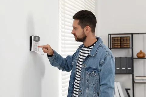 Man entering code on home security system indoors Stock Photos