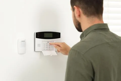 Man entering code on home security system indoors Stock Photos