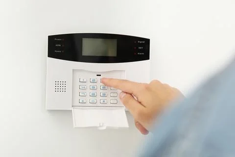 Man entering code on home security system indoors, closeup Stock Photos