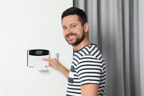 Man entering code on home security system indoors Foto stock