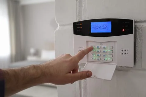 Man entering code on security alarm system at home, closeup Stock Photos