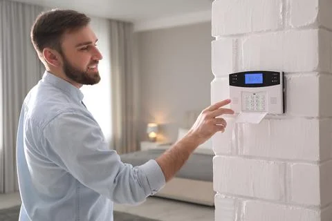 Man entering code on security alarm system at home 스톡 사진