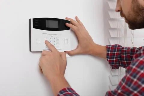 Man entering code on security alarm system at home, closeup Stock Photos