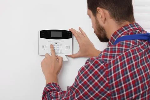 Man entering code on security alarm system at home Stock Photos