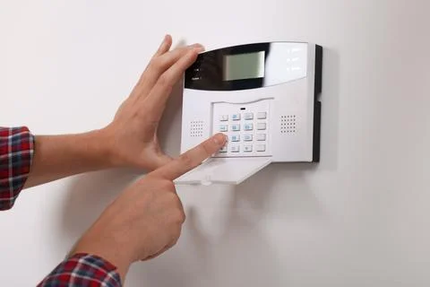 Man entering code on security alarm system at home, closeup Stock Photos