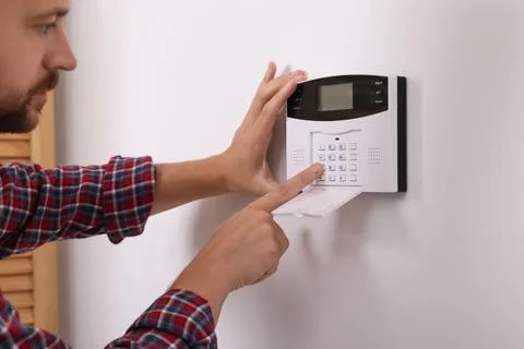 Man entering code on security alarm system at home, closeup Foto stock