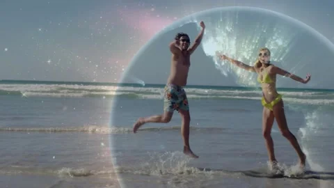 Man entering frame and globe glowing causing couple hopping and splashing on 스톡 동영상 331165907
