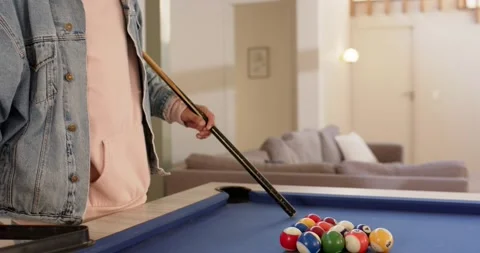 Man is entering frame and racking billiard balls on blue pool table for opening Stock Footage 336784144