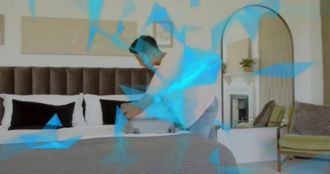 Man entering frame beside bed and unzipping silver suitcase, folding shirts and Stockbeeldmateriaal 317733532