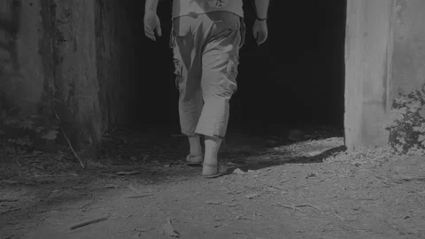 Man entering a gate into the darkness. Black and white video. Hell gate. Stock Footage 155957798