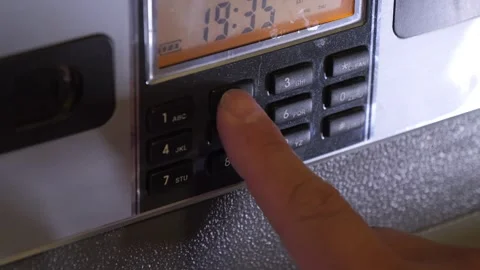 A man enters the correct code into the keypad of a safe Видео 277593025
