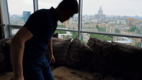 Man enters the frame. Takes a tablet, sits on a sofa Stock Footage 103199509