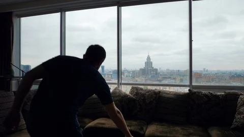 Man enters the frame. Takes a tablet, sits on a sofa Stock Footage 103199657