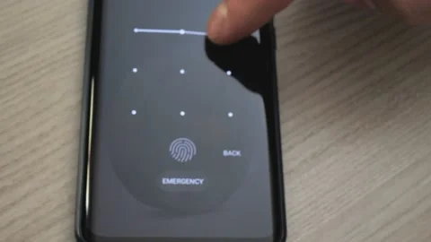 A man enters a graphic PIN code on a smartphone screen to unlock the phone 스톡 동영상 229718750