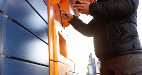 Man enters parcel code on screen and picks up parcel from post office slow Stock Footage 165333147