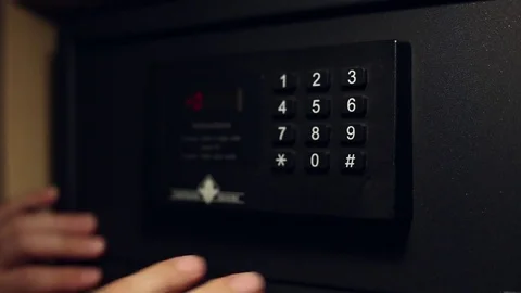A man enters the secret code on a safe deposit box Stock Footage 76480685