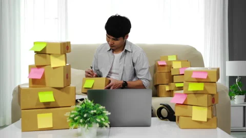 Man entrepreneur working with laptop computer prepare parcel boxes for delivery Stock Footage 143766831