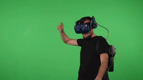 A man with equipment for playing in virtual reality in the Chroma key studio. Stock Footage 316593147