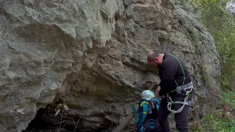 Man equipping himself after climbing on a rock - via ferrata/klettersteig Stock Footage 220737346