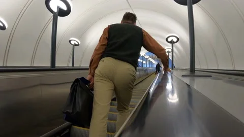 The man on the escalator in the subway is going up. Video contains noises. Stock Footage 163429811