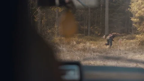 Man escapes from the chasing car and runs in the forest Stock Footage 83223648