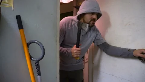 A man with an evil look and a topar in his hand enters the door 4K Stock-Footage 117157689