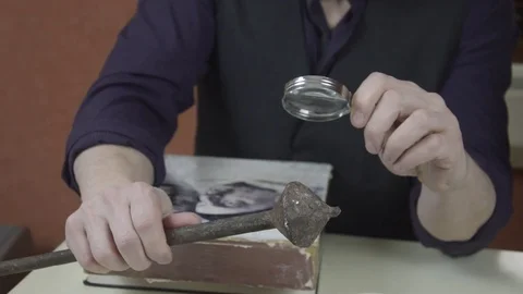 A man examines an ancient piece of iron Stock Footage 74195565