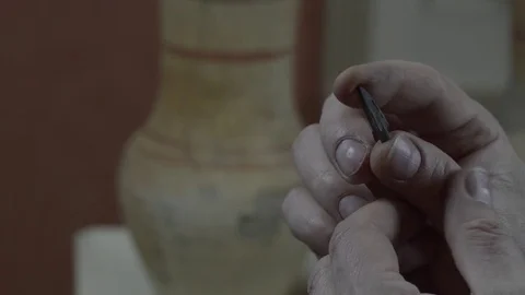 A man examines an antique tip from an arrow Stock Footage 74340403