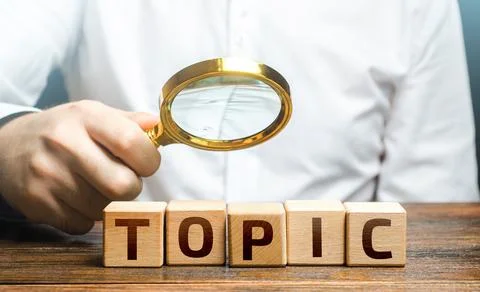 Man examines blocks with topic with a magnifying glass. Conduct research, g.. Stock Photos