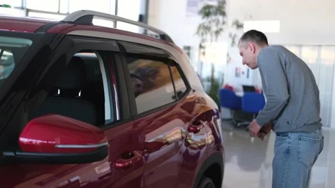 A man examines a car in the cabin for defects. Car rent. Buying a car Stock Footage 237780804