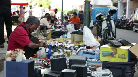 Man examines electrical item on side walk market, malaysia 库存影片 56859861
