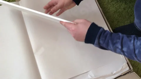 A man examines the elements of a computer desk before assembling. Picks up .. Stock Footage 236689018