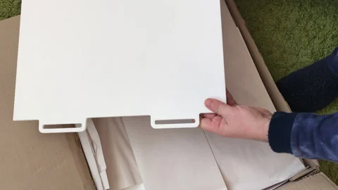 A man examines the elements of a computer desk before assembling. Takes up .. Stock Footage 236689373