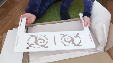 A man examines the elements of a computer desk before assembling. Takes up .. Stock Footage 236689377