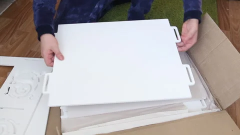 A man examines the elements of a computer desk before assembling. Takes up .. Stock Footage 236689491